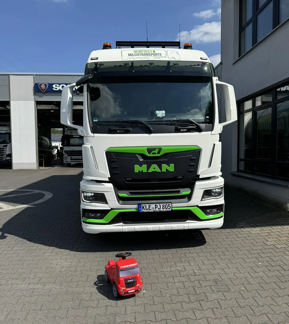 MAN-Zugmaschine von Reintjes von vorn, davor ein rotes Spielzeug-Lkw